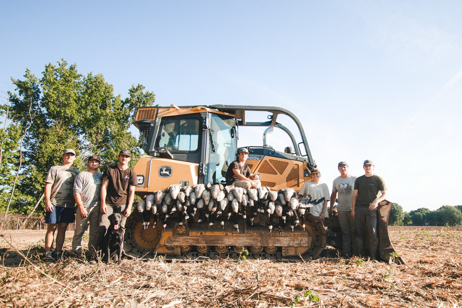 The Hometown Honkers crew standing behind a dozer blade lined with Canada geese